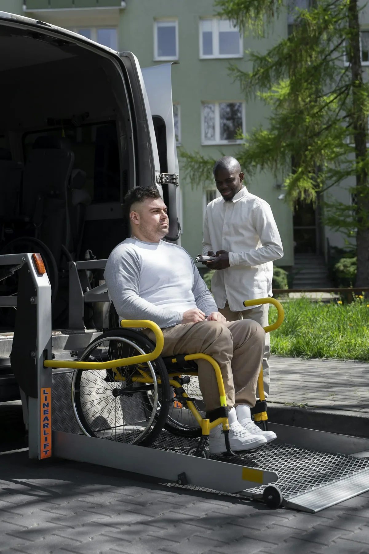 An attendant lowers a rider's wheelchair on the van lift.